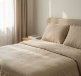 Chambre paisible avec literie en lin beige et lumière douce du matin filtrant à travers les rideaux