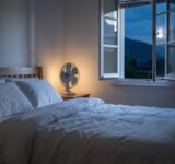 Chambre calme avec draps en lin et ventilateur pour mieux dormir pendant les nuits chaudes d'été