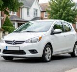 Petite citadine d'occasion propre garée dans une rue résidentielle calme